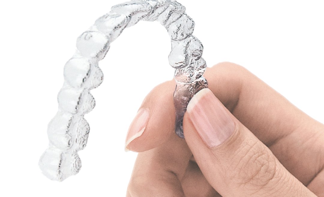Aligneur Invisalign transparent tenu à la main